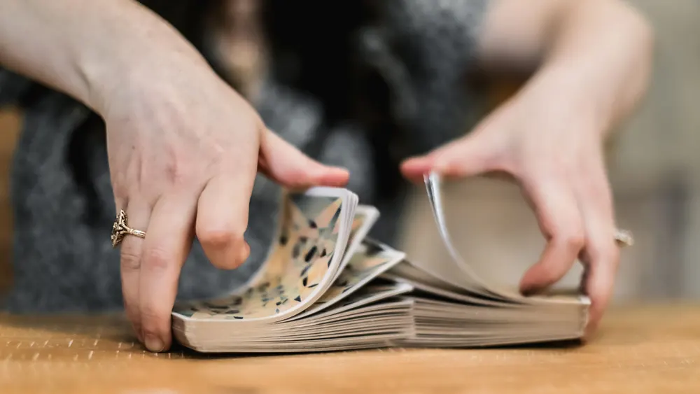 How to Read Tarot Cards for Beginners: A Step-by-Step Guide 6 Person shuffling tarot cards in preparation for a reading