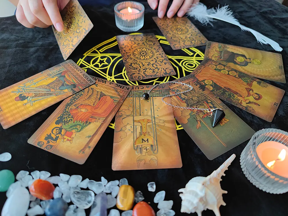 Tarot cards and crystal pendulum arranged on a wooden table for divination clarity