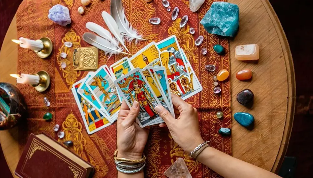 The Importance of Grounding Before a Tarot Reading 6 A neatly arranged Celtic Cross tarot spread on a wooden table with grounding elements like candles and stones for an accurate reading